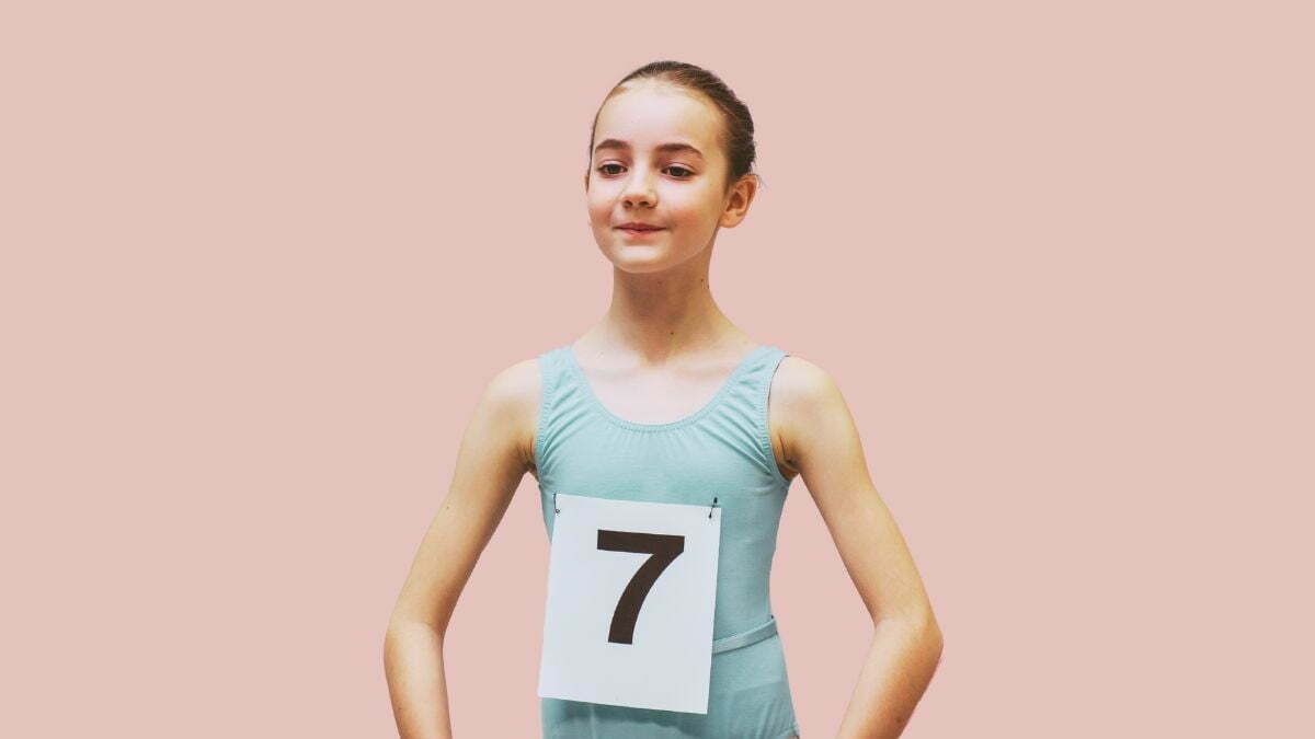 Een jong meisje klaar voor haar auditie bij Ndigo — het nummer opgespeld, de schouders recht, de rest komt vanzelf.