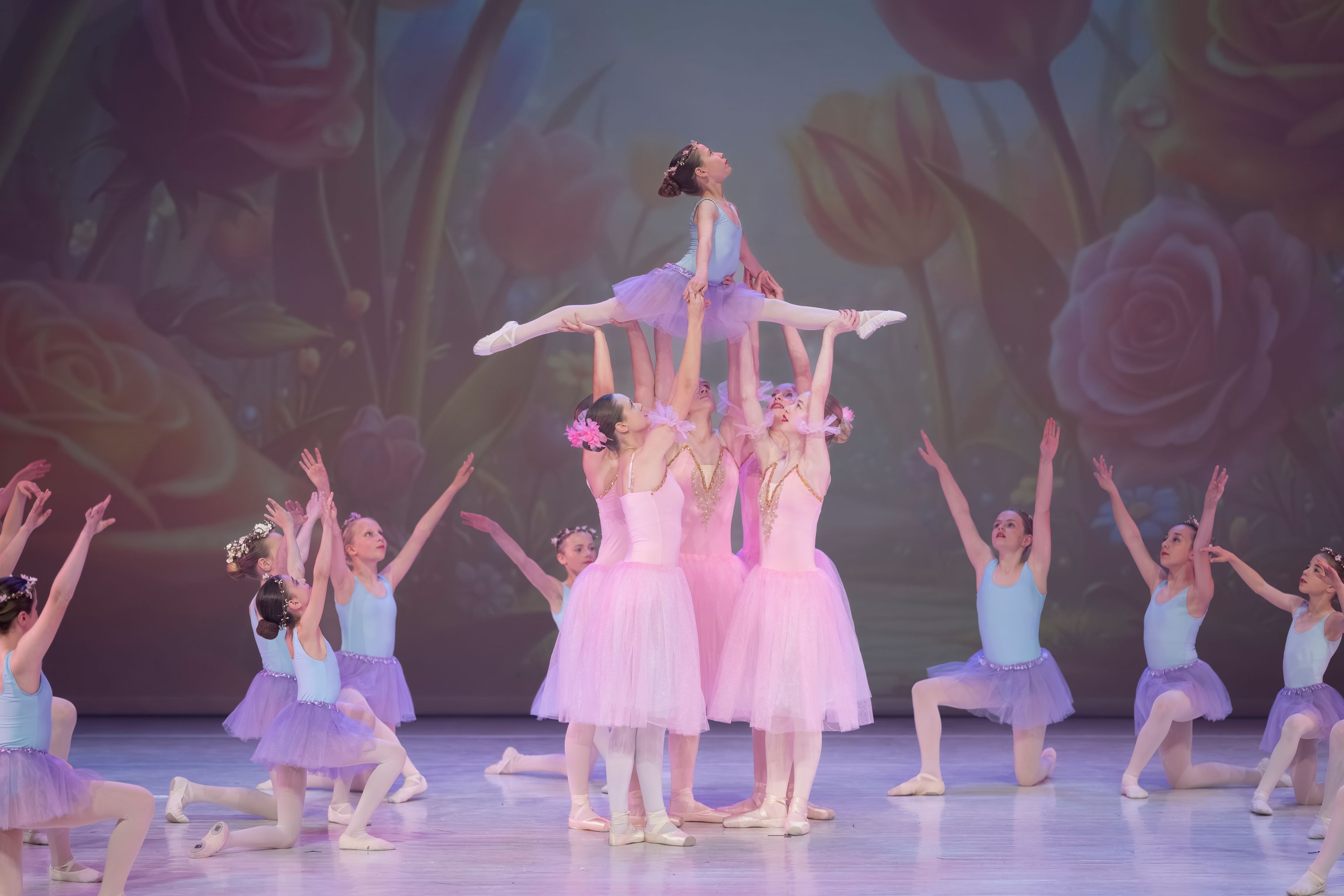 Ballet met klein en groot bij Ndigo: dansers in lichte tutu’s voeren samen een lift uit op het podium.