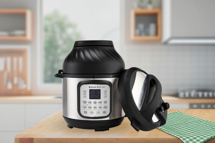 Op het aanrecht staat een Instant Pot Vortex Airfryer met een digitaal display; het deksel ligt eraf en ligt er vlak naast, met een groene geruite handdoek ernaast.